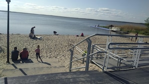 A beach with a wooden walkway leading to a dock. - Holiday Home in Nowe Warpno by the Harbor (Nowe Warpno)