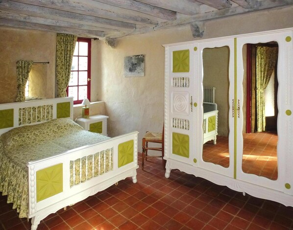 A bedroom with a bed, a wardrobe, a chair, and a window with curtains. - Manor Near Mont St. Michel and Contentin Beaches (Port-Bail-sur-Mer)