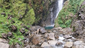 A waterfall cascading down a rocky cliff surrounded by lush greenery. - Studio apartment at the foot of the slopes (St Aventin)
