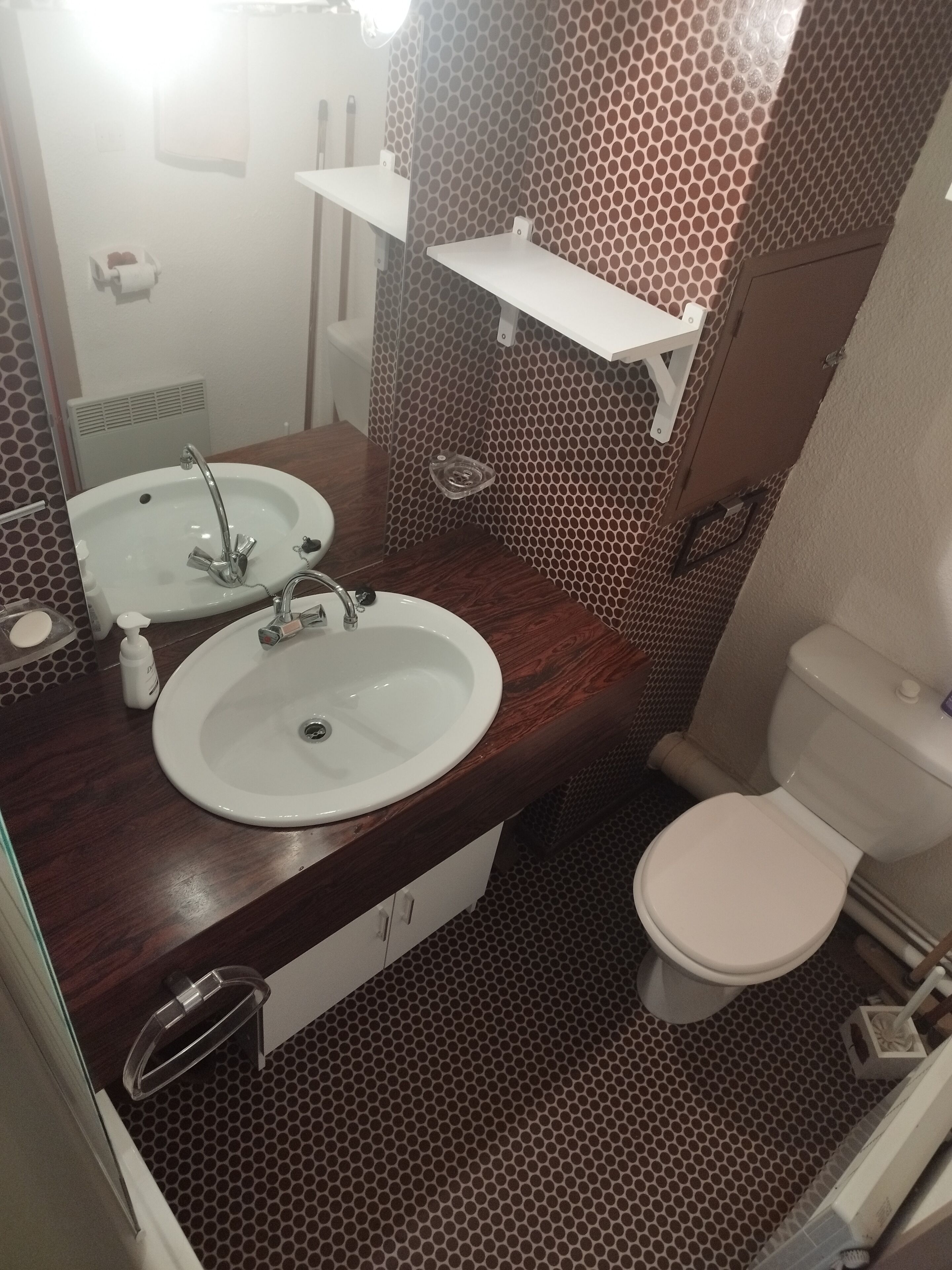 Ein Badezimmer mit zwei Waschbecken, einer Toilette und einem Spiegel.