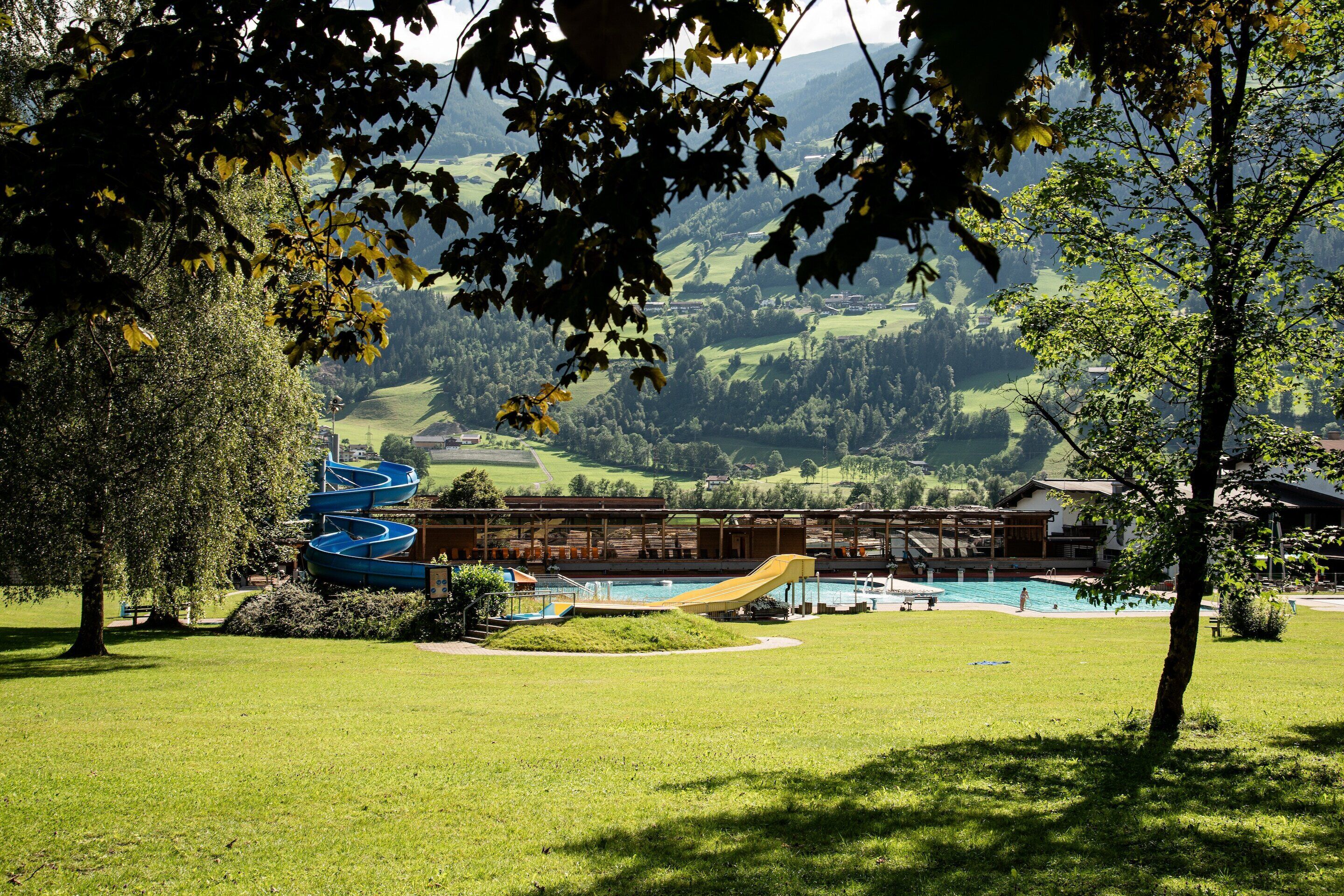 Een hotel met een zwembad, boten en uitzicht op het omliggende landschap.