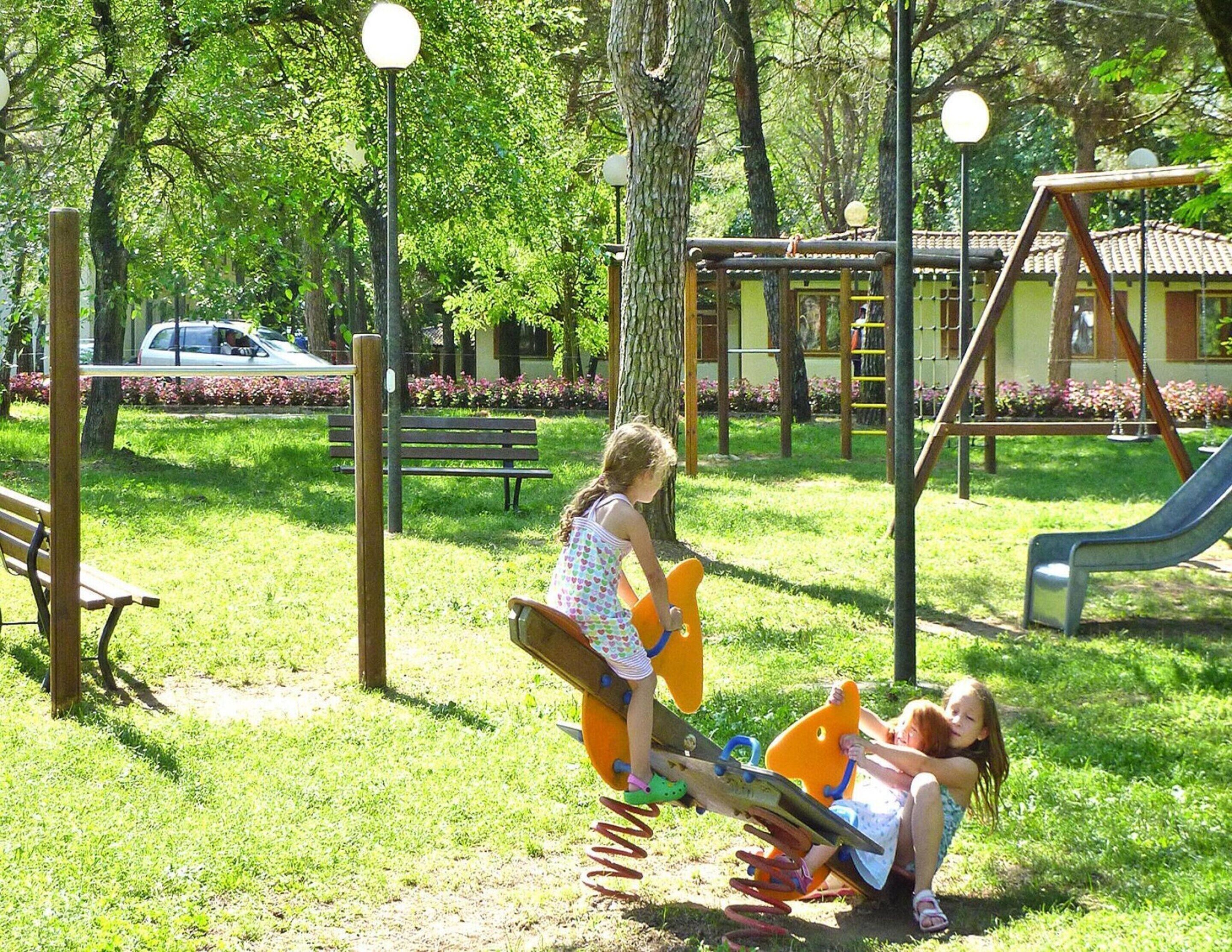 A playground with a slide, swings, and a bench.