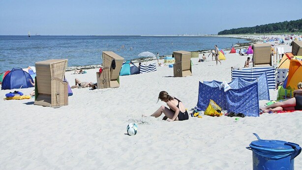 A beach with tents and beach chairs, a volleyball, and a clear sky. - Gemuetliche Doppelhaushalfte in Lubmin (Lubmin)