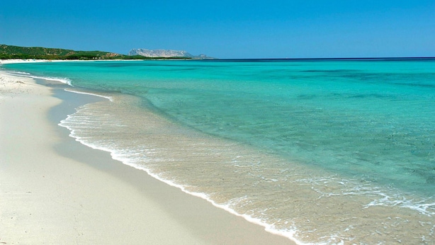A beach with clear turquoise water and a sandy shore. - Apartment in Budoni With Terrace (Budoni)