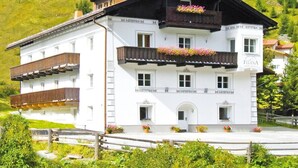 A multi-story building with balconies, a sign reading 'FLIANA,' and flower boxes. - Apartment in Ischgl Overlooking the Mountains (Ischgl)