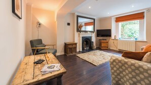 A living room with a fireplace, a television, and a window with curtains. - Gorgeous Garden Flat - Top Location (Cotham)