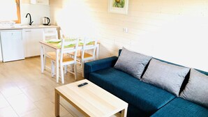 A compact living space with a kitchenette, a dining area, and a sofa. - Two-story Holiday Homes Close to the Seaside Beach (Mielno)