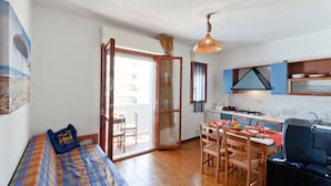 A compact living space with a bed, a dining area, and a kitchenette. - Residence Valbella Beach (San Michele al Tagliamento)