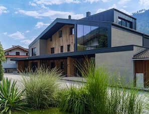A modern two-story house with a flat roof, large windows, and a wooden facade. - Apartment in Bramberg Near Wildkogel Arena (Bramberg am Wildkogel)