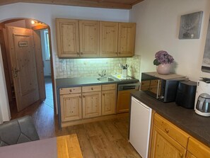 A kitchen with wooden cabinets, a dishwasher, and a coffee machine. - Apartment in Bramberg Near Wildkogel Arena (Bramberg am Wildkogel)