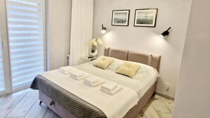 Une chambre à coucher moderne avec un lit, des tables de chevet et des œuvres d’art accrochées au mur.