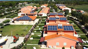 Un quartier résidentiel où les maisons sont équipées de panneaux solaires et où se trouve un terrain de jeux.