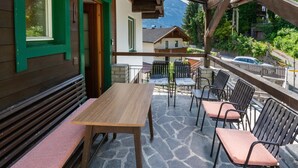 A wooden table and chairs on a stone patio with a view of a mountain. - Chalet in Fugen Near Spieljochbahn (Fuegen)