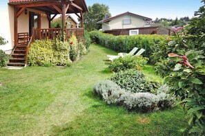 A well-maintained garden with a wooden deck, a lawn, and various shrubs. - Holiday Home on Wolin Island Near Lagoon (gmina Wolin)