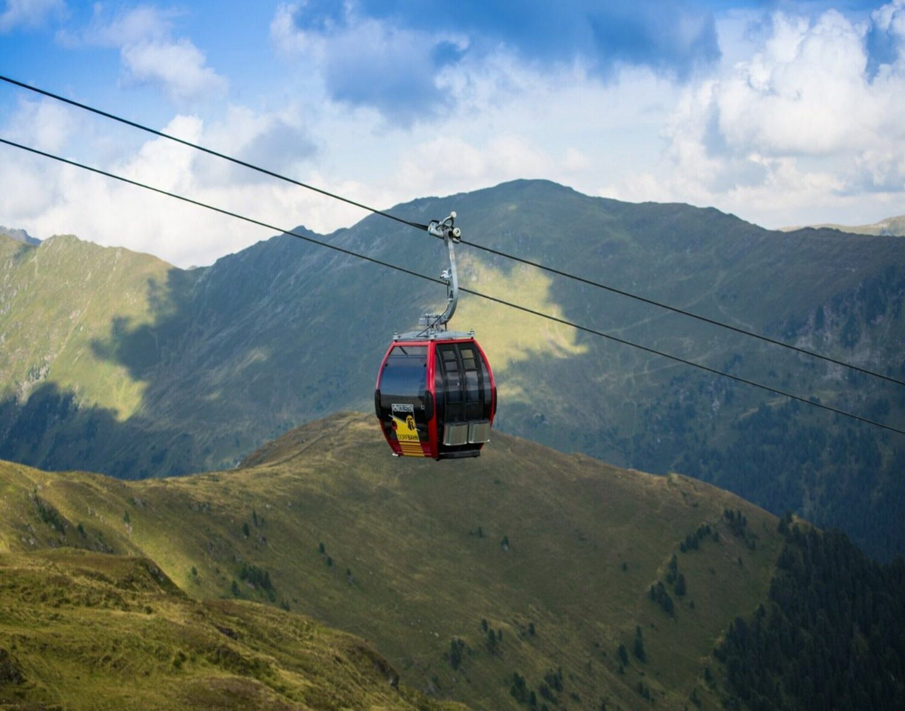 A cable car moving over a mountainous landscape.