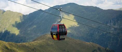 A cable car moving over a mountainous landscape.