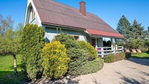 A single-story house with a red roof, a porch with a white railing, and a chimney. - Large Holiday House With Terrace, Bobolin (Darlowo)