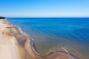 A coastal beach with clear blue waters and a sandy shoreline. - Apartment in Sianozety Near the Beach (Ustronie Morskie)