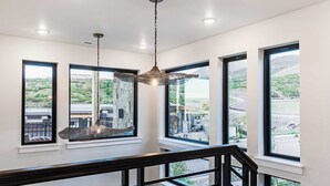 Un interno moderno con ampie finestre, un lampadario e una scala.