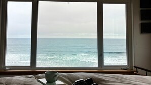 Ein Schlafzimmer mit einem großen Fenster mit Meerblick.