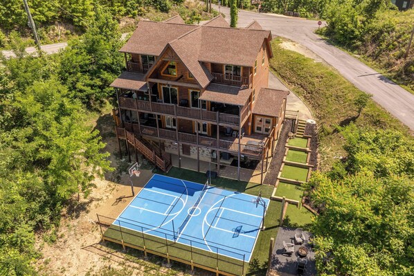 A large wooden house with multiple balconies, a basketball court, and a driveway. - Indoor Pool, Volleyball Beach, Mountain View (Gatlinburg)