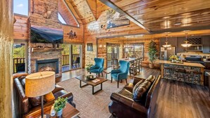 A spacious log cabin interior with a fireplace, a dining area, and a kitchen. - Indoor Pool, Volleyball Beach, Mountain View (Gatlinburg)