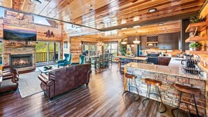 A spacious living area with a fireplace, wooden ceiling, and a stone accent wall. - Indoor Pool, Volleyball Beach, Mountain View (Gatlinburg)