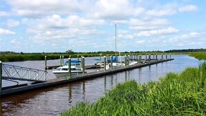 A calm waterway with a dock, boats, and a bridge. - Beautiful, Newly-Renovated Condo on the Altamaha River in Darien with BoatSlip (Darien)