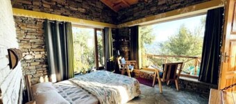Cozy bungalow nestled in the Himalayas, snow-capped peaks, Kumaoni culture.
