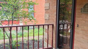 A red brick building with a black-framed glass door and a welcome mat.