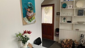 Ein Essbereich mit Tisch, Stühlen, einer Vase mit Blumen und einem Bild an der Wand.