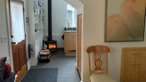Ein gemütliches Wohnzimmer mit Kamin, einem Holzstuhl und einem Bücherregal.