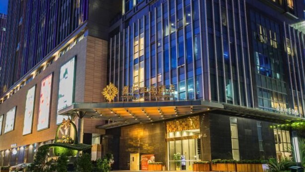 A modern hotel with a prominent entrance, large windows, and a well-lit facade. - Starry Four Sea Hotel (Foshan)