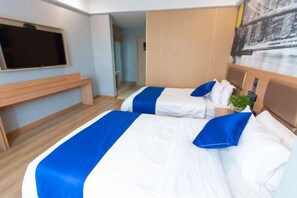Una habitación de hotel con dos camas, un escritorio y un televisor.