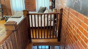 Un escalier en bois offrant une vue sur une chambre située à l’étage supérieur.