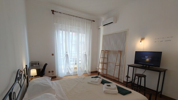 Una camera d'albergo con un letto grande, una televisione, una scrivania e una sedia.