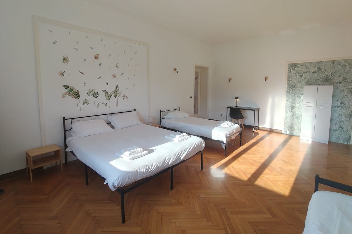 A room with two beds, a desk, and a wardrobe.