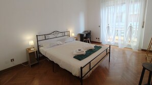 Una camera da letto con un letto, lampade sui comodini, una scrivania e una sedia.
