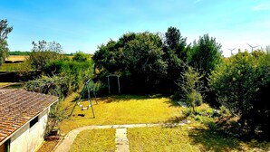 A backyard with a swing set, a small shed, and a garden area. - Vacation House in Quiet Village, Welcome to our 3 bedroom countryside retreet (MONNERVILLE)