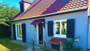 A house with a red-tiled roof, a small porch with a bench, and a number '10' on the wall. - Vacation House in Quiet Village, Welcome to our 3 bedroom countryside retreet (MONNERVILLE)