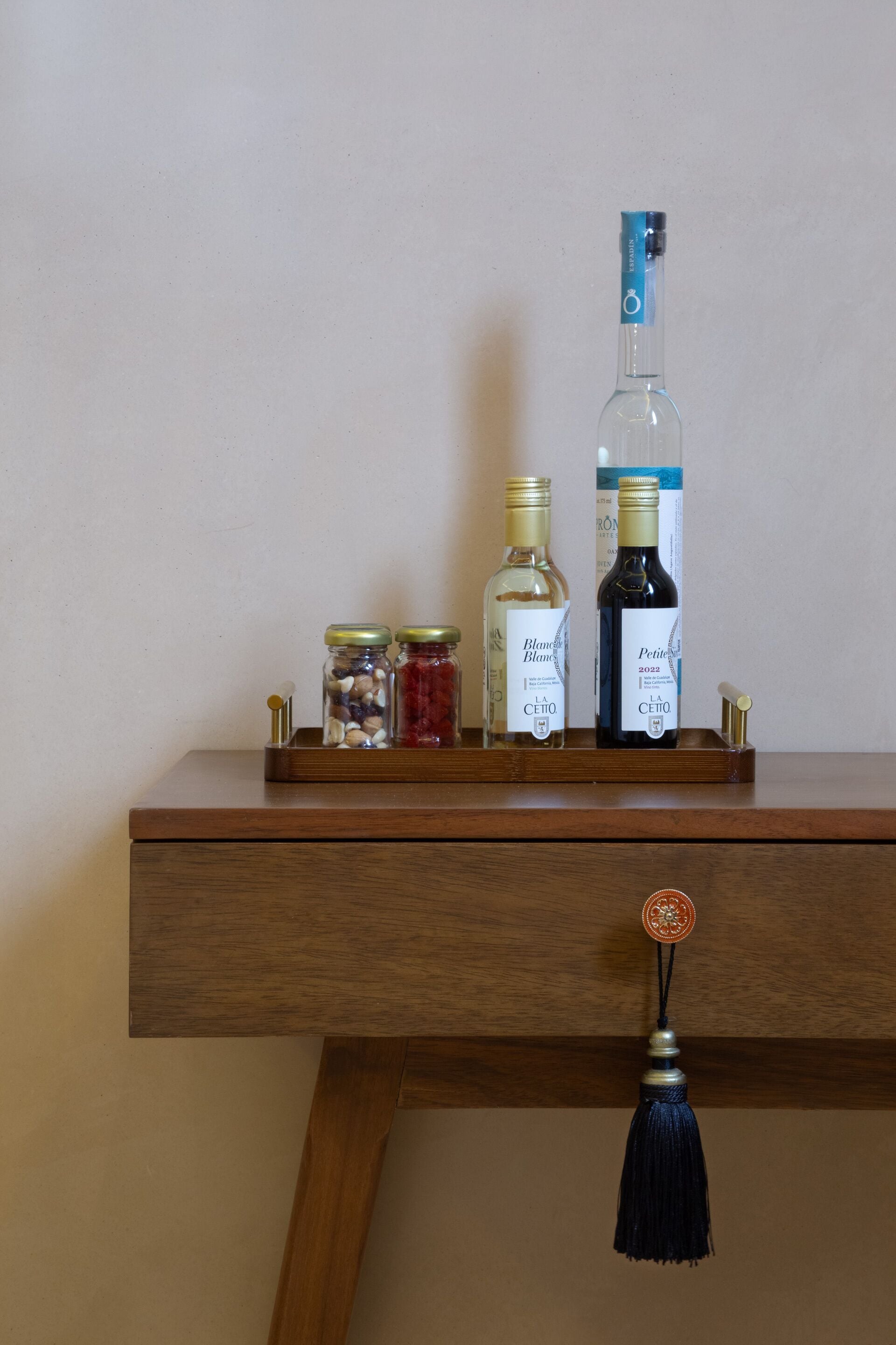 Una bandeja de madera con botellas y frascos sobre un escritorio.