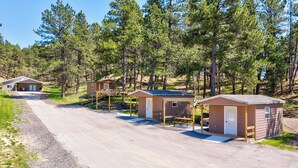 A row of small cabins with attached porches, surrounded by a forested area. - Cozy queen bed cabin with WiFi, fitness room in enchanting Aladdin (Aladdin)
