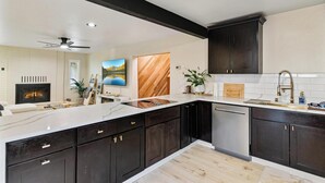 A modern kitchen with dark cabinetry, a white countertop, and a built-in oven.