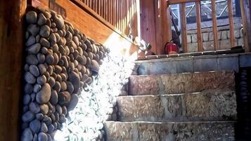 A staircase with stone steps leading to a wooden door with a metal gate.