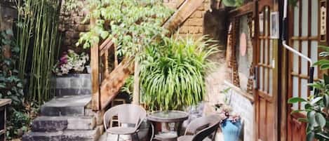 Un patio con escaleras, mobiliario exterior y plantas en macetas.
