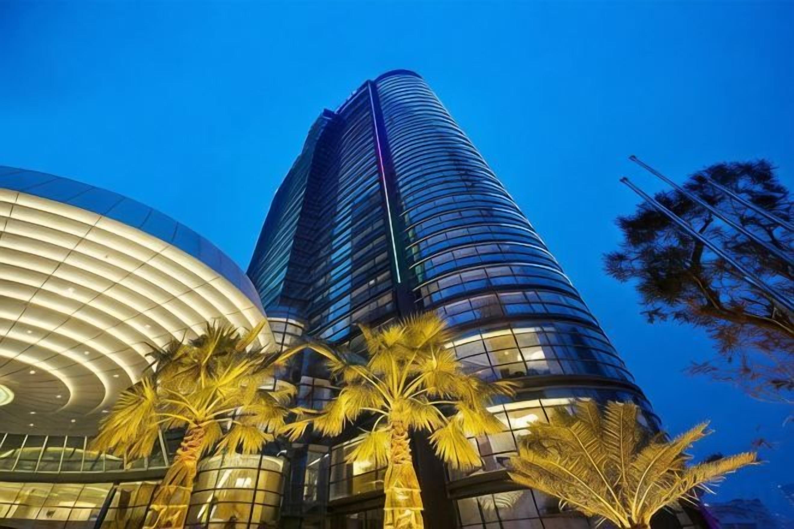 Un edifici modern amb façana corbada i una torre alta i esvelta.