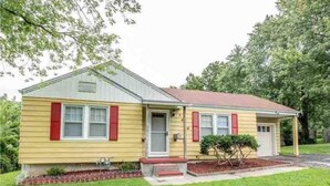 A single-story house with a gabled roof, a front porch, and a small front yard. - Arlington House - 5 min to Arrowhead / FIFA (Independence)