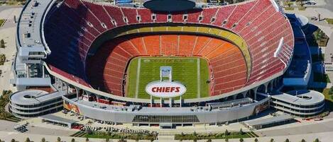 A stadium with a large central field and multiple tiers of seating.
