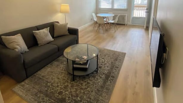 Una sala de estar moderna con un sofá, una mesa de centro y un comedor con sillas y una mesa.