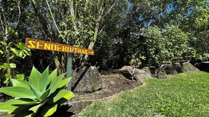 Señal del Sendero Trail en un entorno natural con rocas y vegetación.